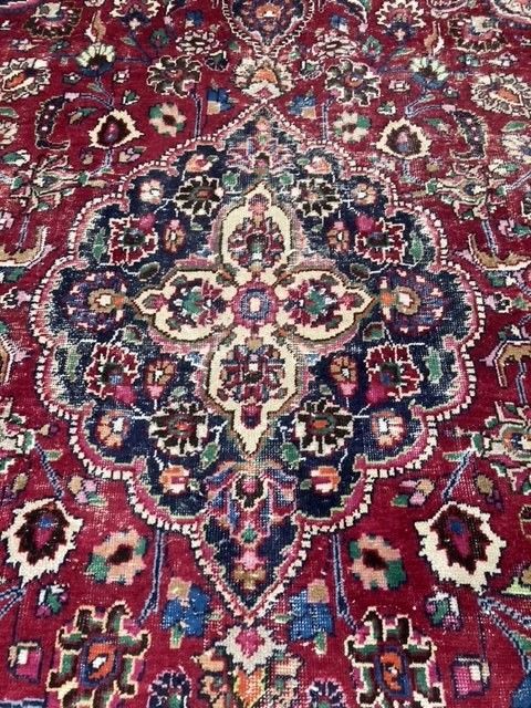 A Heriz style burgundy ground carpet, 380 x 360cm